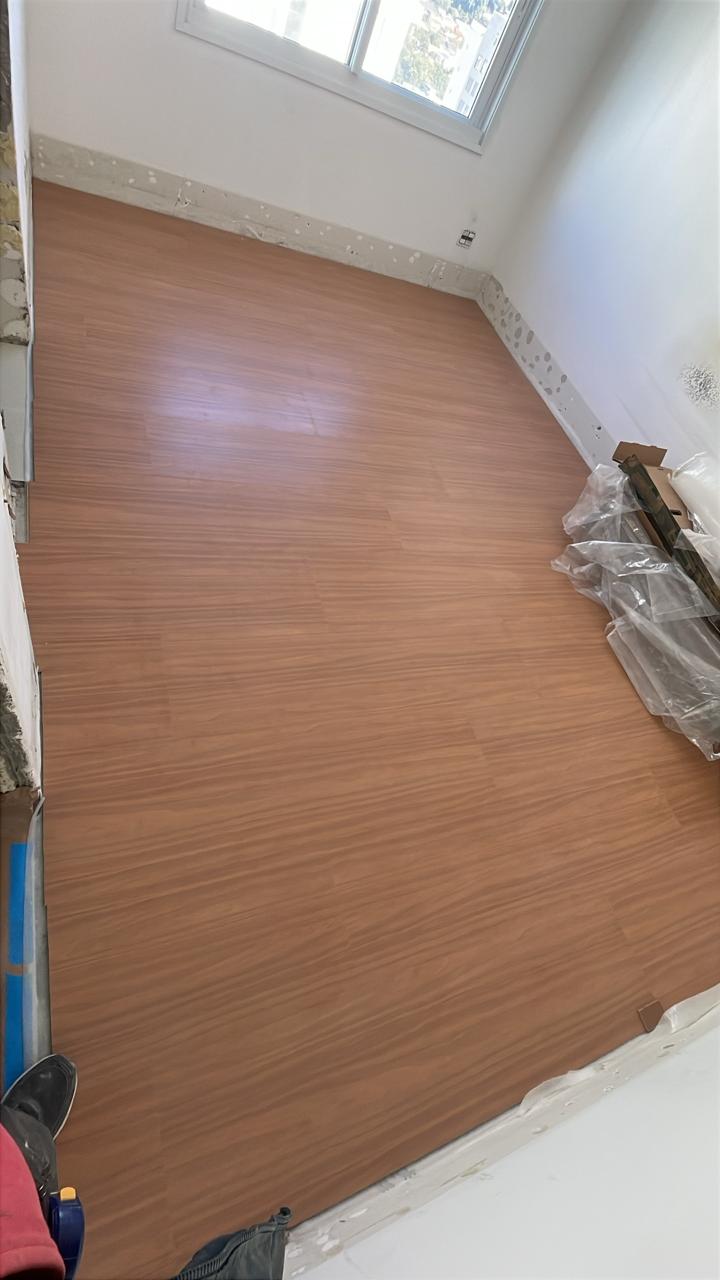 Piso laminado em finalização — quarto concluído.