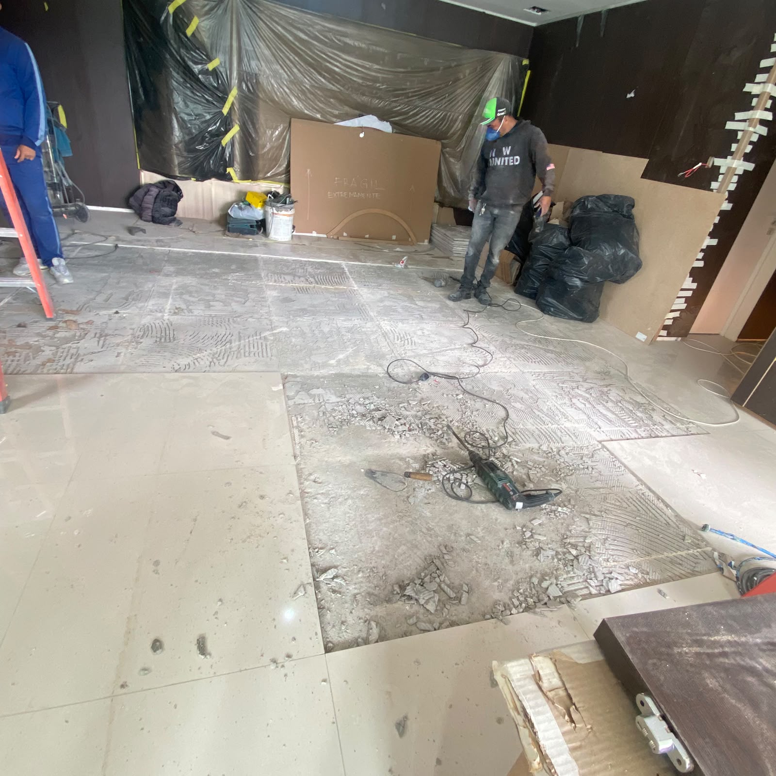 Demolição em andamento — retirada do porcelanato existente.