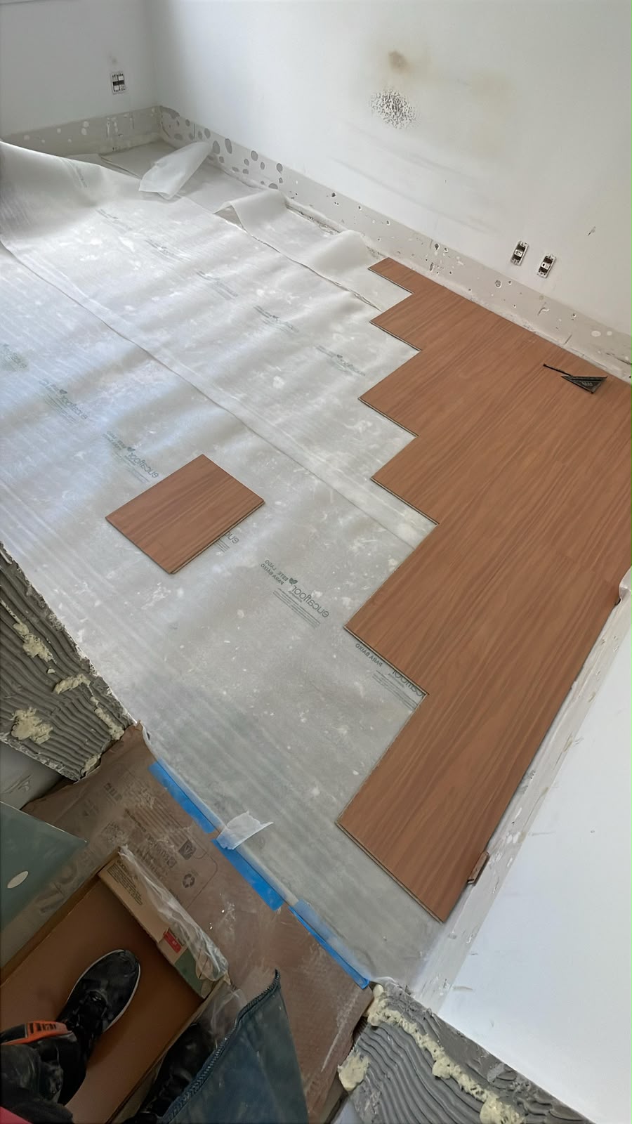 Instalação do piso laminado em andamento — preparação da base e primeiras réguas.